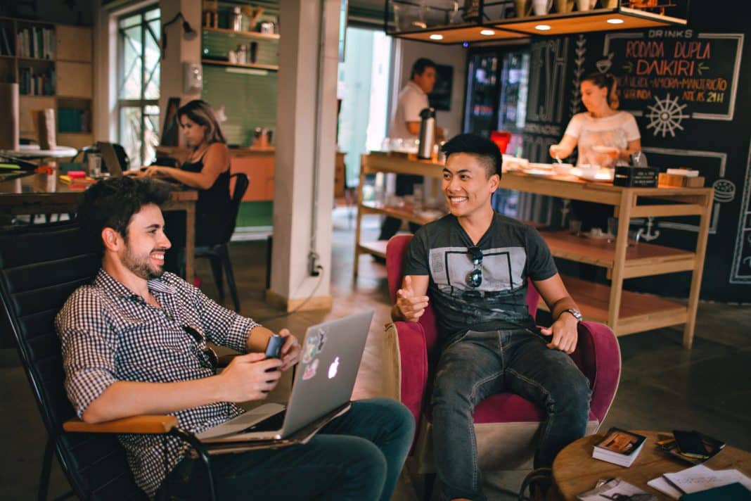 Friends chatting indoors while sitting in armchairs