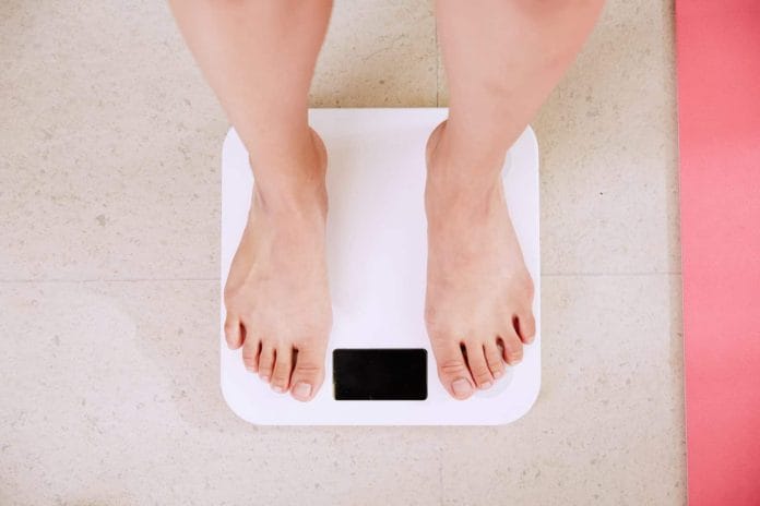 Person weighing themselves on scales