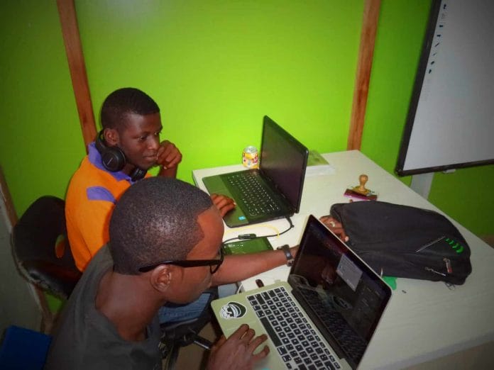 Two young men using laptops