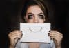 A crying person holding a smile over their mouth