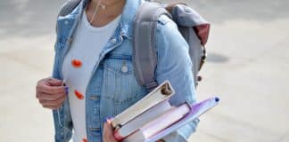 A woman clutches folders and books