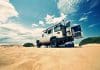 A car on sand, with the back doors wide open