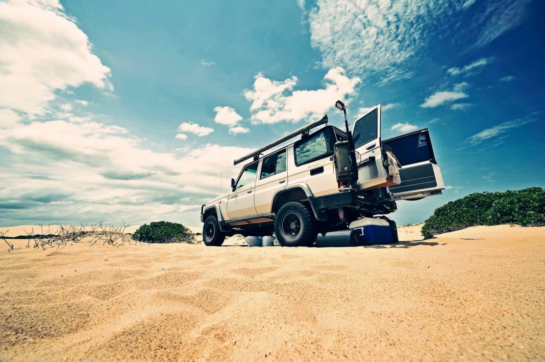 A car on sand, with the back doors wide open