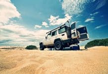 A car on sand, with the back doors wide open
