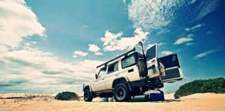 A car on sand, with the back doors wide open