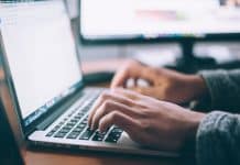 A pair of hands typing on a keyboard