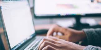 A pair of hands typing on a keyboard
