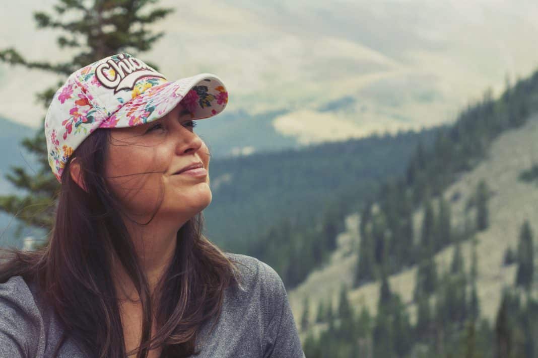 Standing in front of tree-covered mountains, a Mexican woman smiles