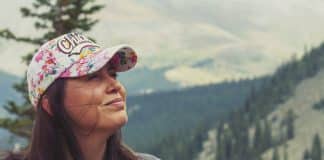 Standing in front of tree-covered mountains, a Mexican woman smiles