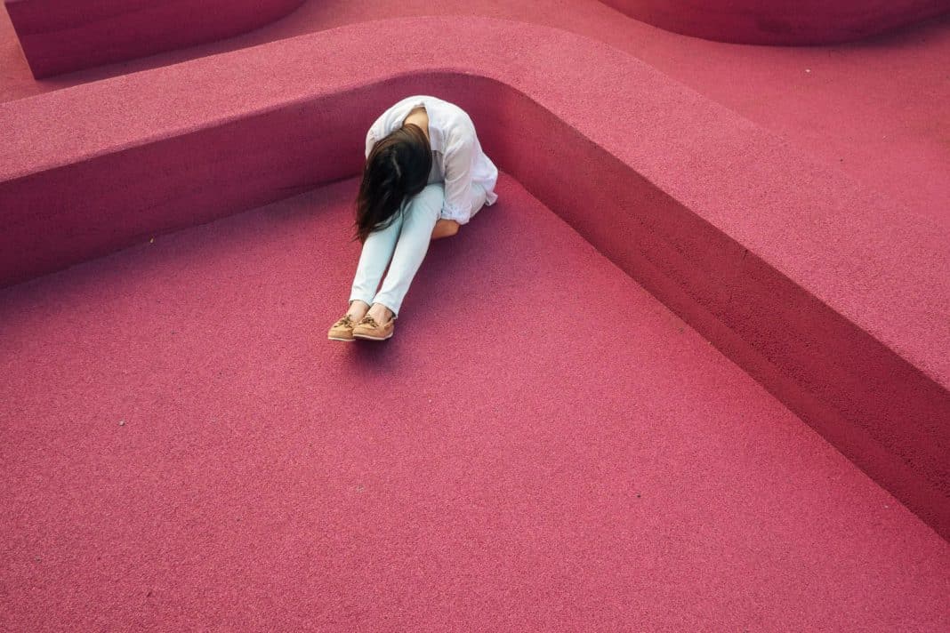 Person curled up on the floor in despair