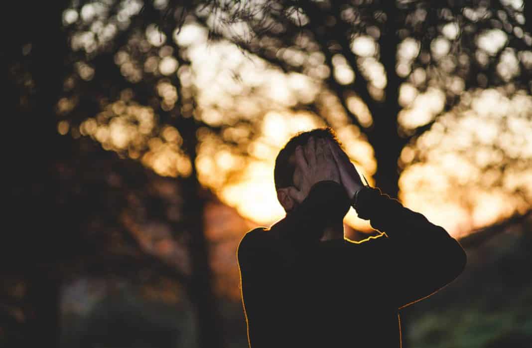 A man covers his face with his hands