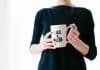 A woman holds a cup that says 'Like a boss'