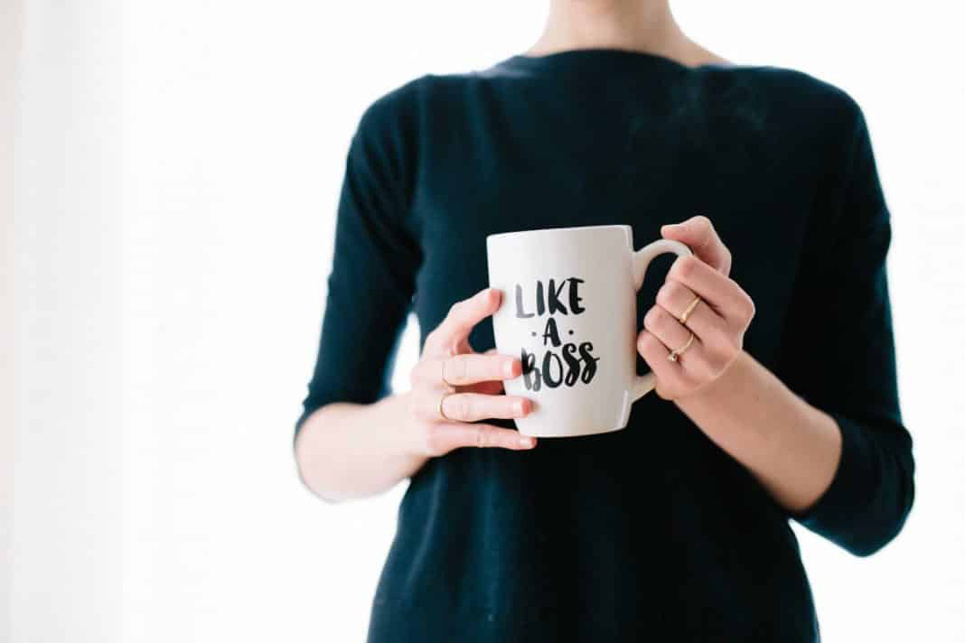 A woman holds a cup that says 'Like a boss'