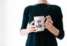 A woman holds a cup that says 'Like a boss'