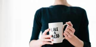 A woman holds a cup that says 'Like a boss'