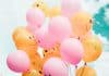 A number of balloons with smiling faces drawn on them