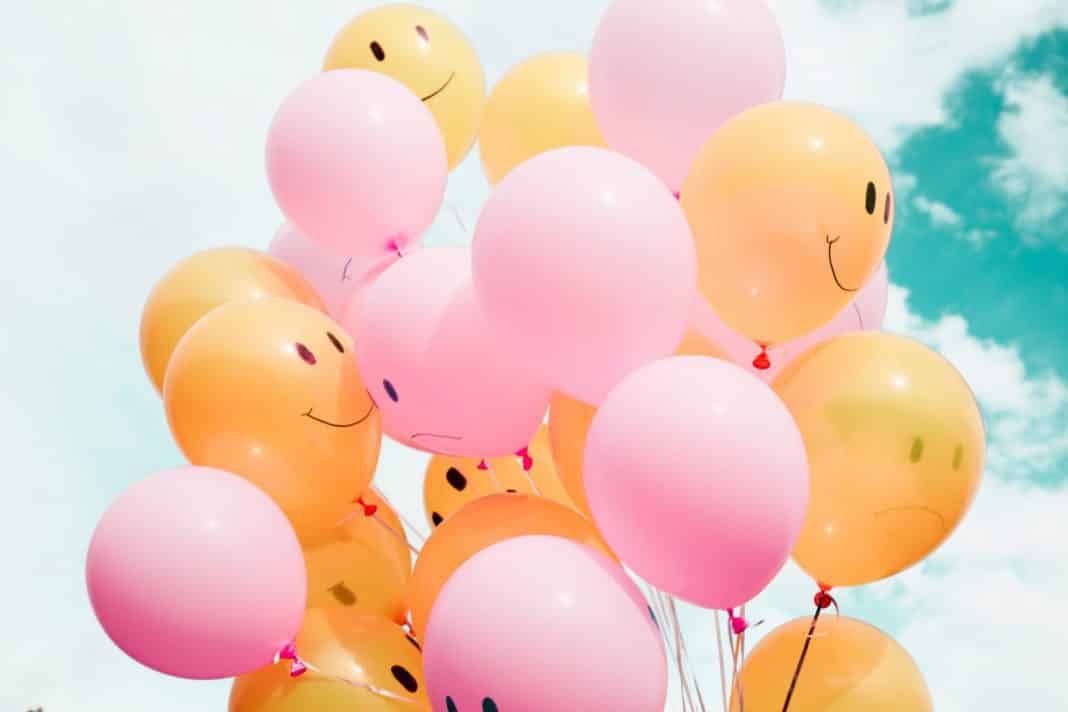 A number of balloons with smiling faces drawn on them