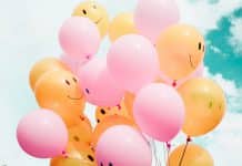 A number of balloons with smiling faces drawn on them