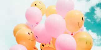 A number of balloons with smiling faces drawn on them