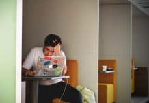 A stressed student uses his laptop at a desk