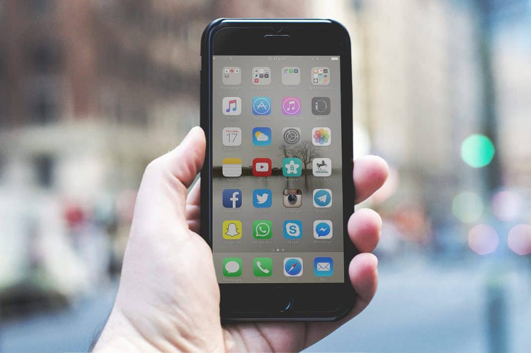 A phone with a variety of social media apps on the screen.