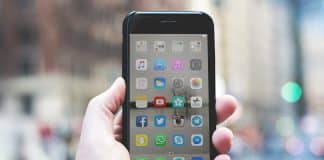 A phone with a variety of social media apps on the screen.