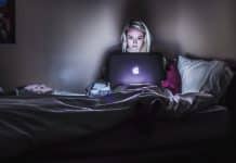 A woman working on a Macbook in the dark