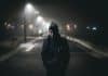 A man walking along a dark road at night