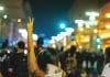 A protester makes a V symbol above her head