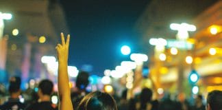A protester makes a V symbol above her head