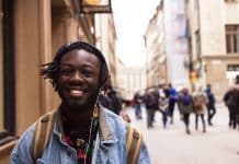 A young black man standing in the street and smiling