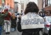 A protester wearing a slogan saying 'Power to the peaceful'