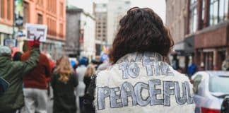 A protester wearing a slogan saying 'Power to the peaceful'
