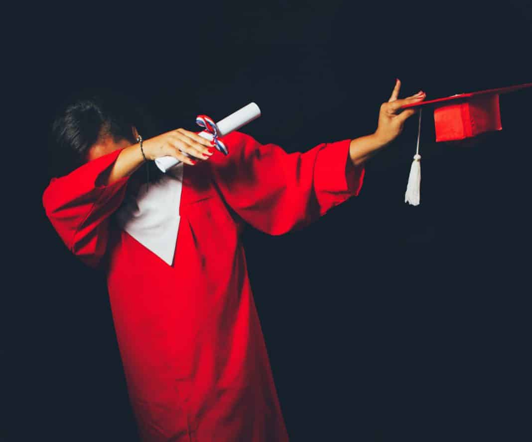 A student dabs in their graduation outfit
