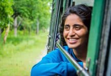 An Indian girl smiles while looking out the window of a vehicle