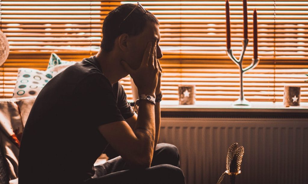 A man covers his face with his hands from stress