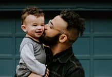 A father kisses his young child on the cheek