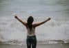A young woman stretches out her arms above her head
