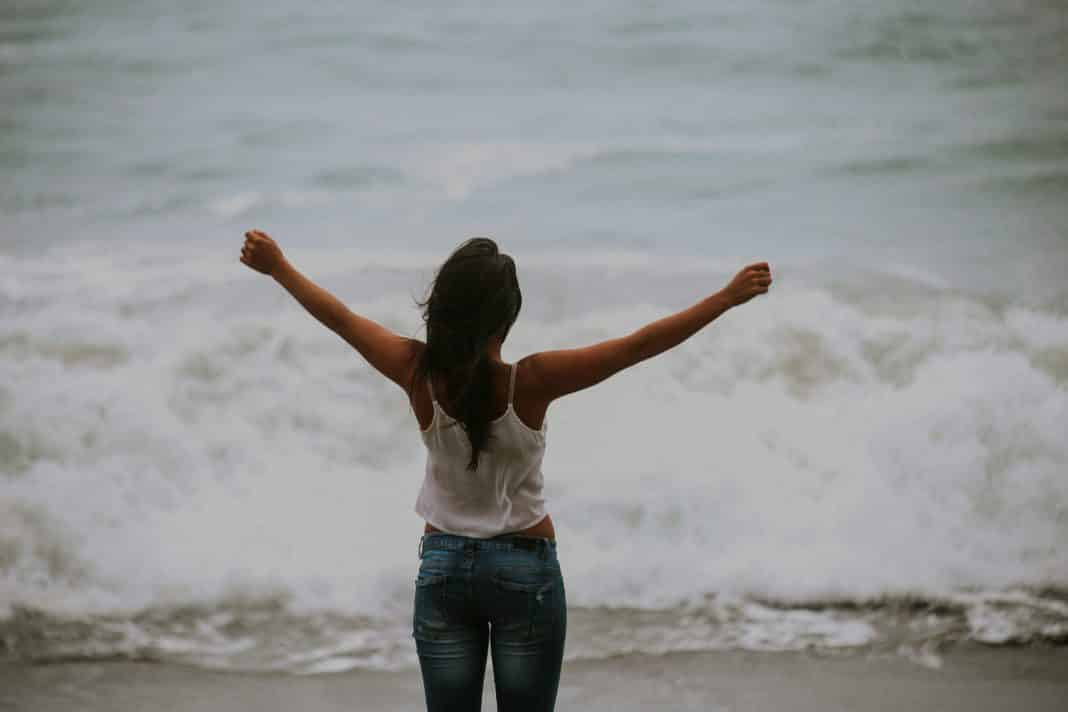A young woman stretches out her arms above her head