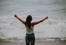 A young woman stretches out her arms above her head