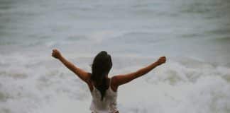 A young woman stretches out her arms above her head