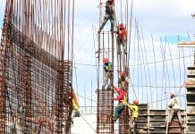 Construction workers assemble a building