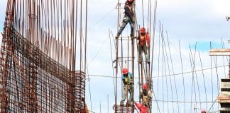 Construction workers assemble a building