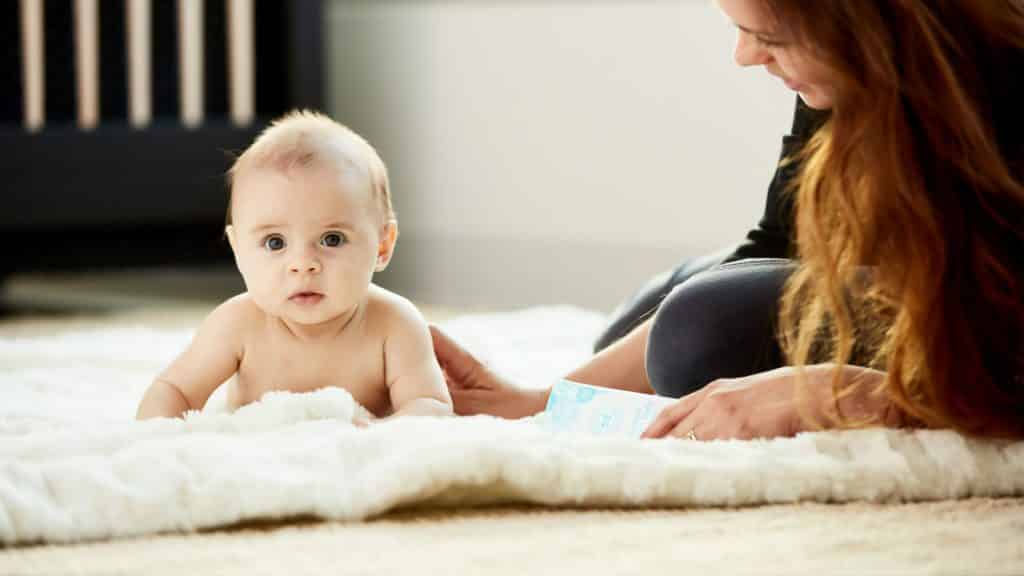 A mother watches her crawling baby