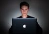A young man uses a laptop