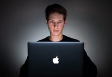A young man uses a laptop