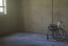 An empty wheelchair in a tatty room