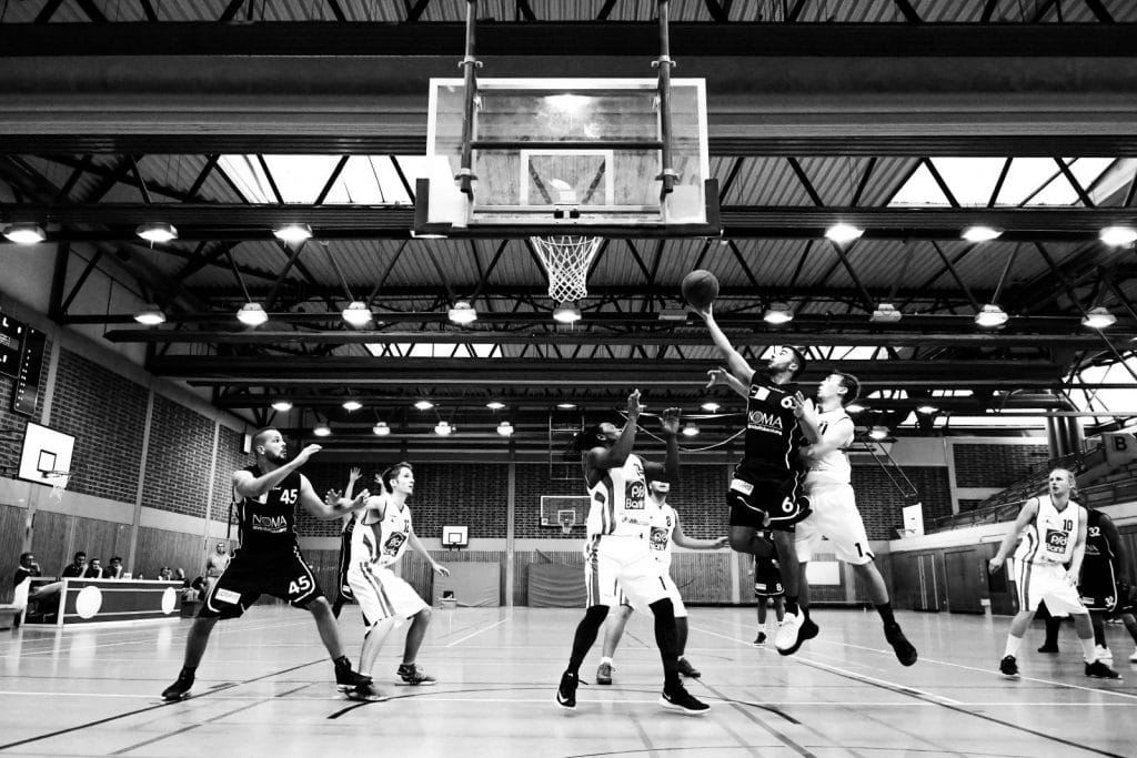 A group of young men play basketball