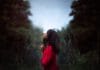 A young woman in a red dress prays