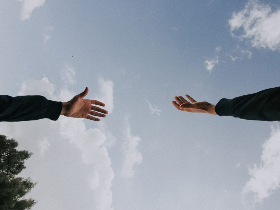 A hand reaches out to another hand